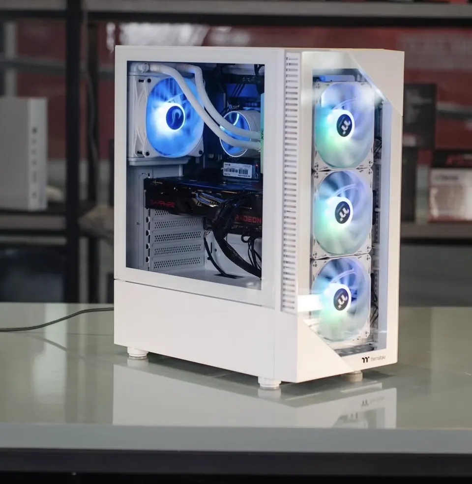 Computador de gabinete branco com refrigeração líquida e ventoinhas iluminadas, montado pela Upar sobre a bancada da loja